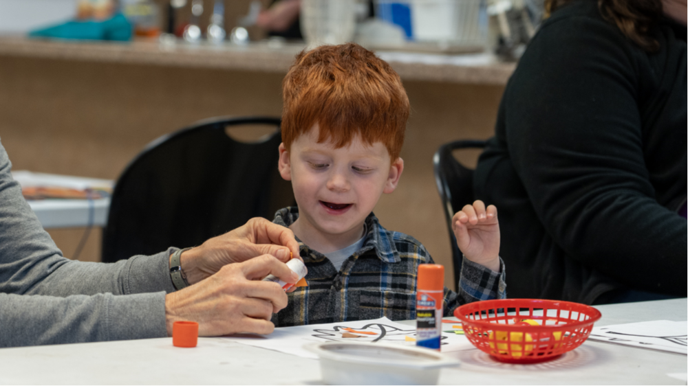Little red headed boy doing a craft project