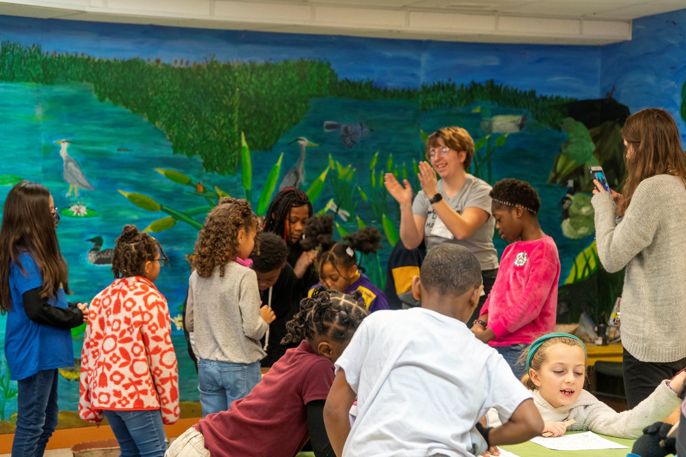 Students do Native American-inspired craft projects and dance in the background.