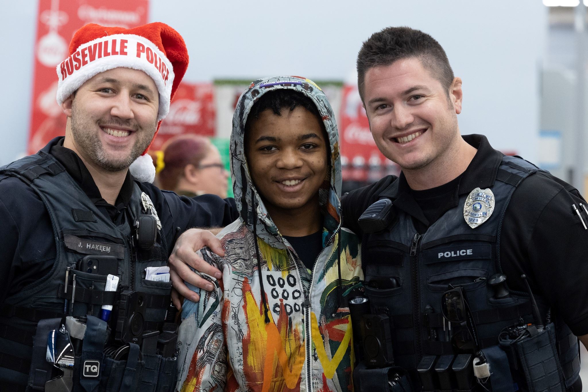Police Officers pose with a young man during the 2023 Shop with a Cop shopping spree.