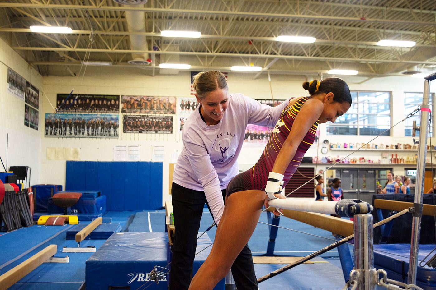 Gymnastics Supervisor Kristy Phillippi helps a student work on her form.